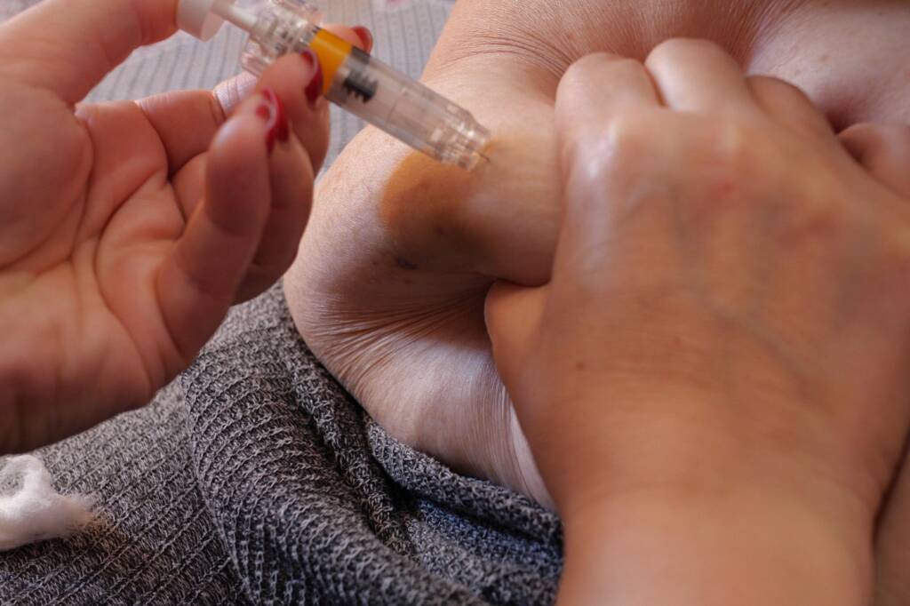 Woman is injecting hormones to belly with syringe. IVF concept close up